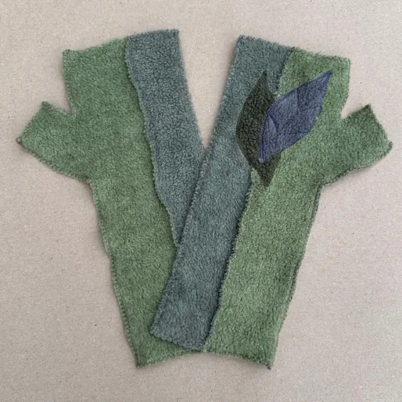 a pair of Feeline Clothing two tone mittens with leaves in soft green and blue grey