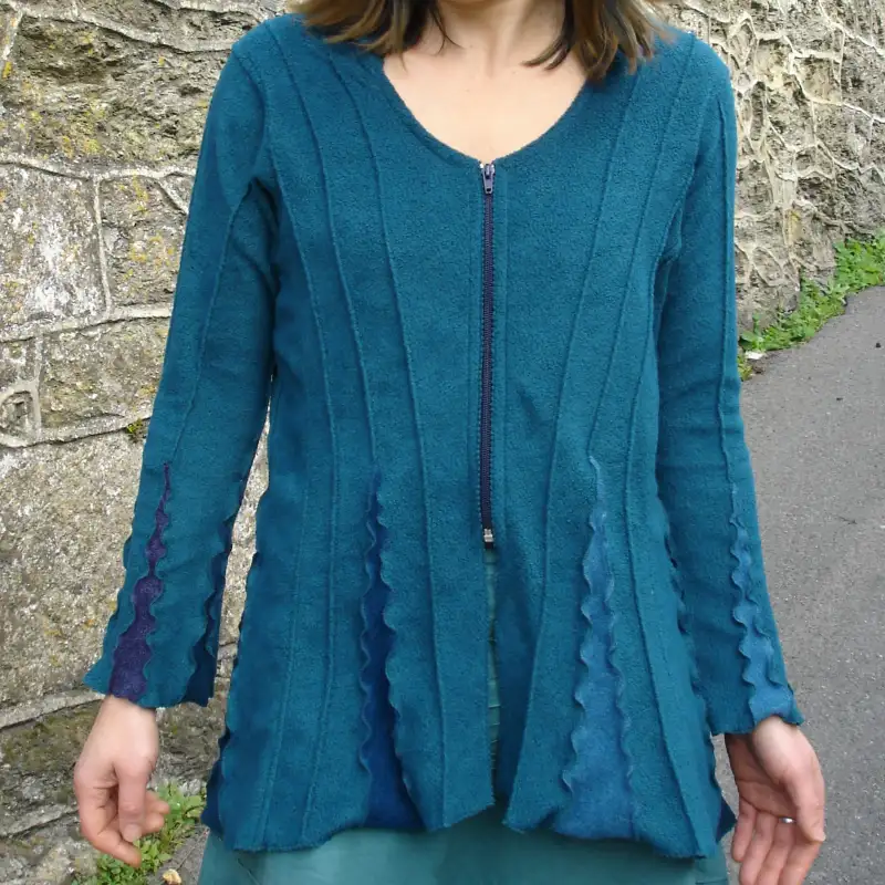 A detail of a Feeline Clothing jacket/cardigan in marine colurway showing the inserts effect, and with a front zip