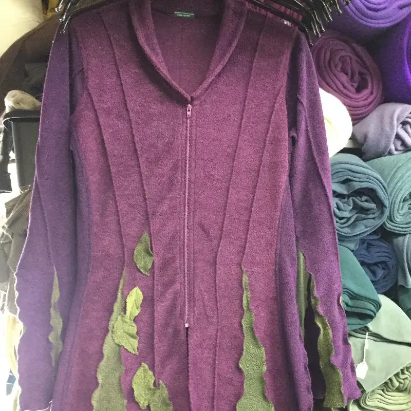 A Feeline Clothing jacket with collar in purples, with bright green leaves appliquéd on and around the green inserts from the waist down. a customer's made-to-measure order, both colour choices and the leaves.