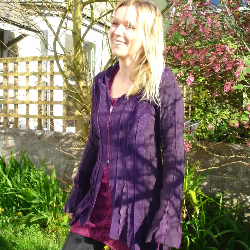 Feeline Clothing cardigan/jacket with hood and front zip, in violet colour way modelled in a garden setting