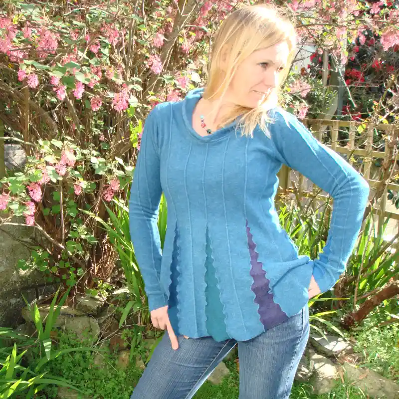 Feeline Clothing top, with collar, in marine colour way, modelled against a background of pink blossom