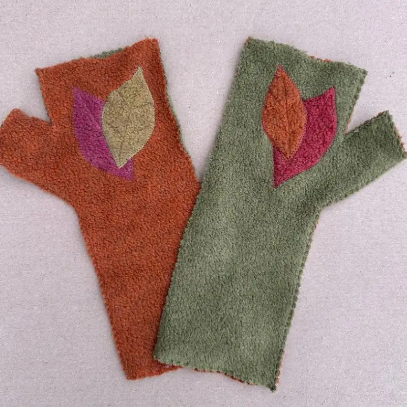 a pair of origina one-offl Feeline Clothing mittens, in green and orange, with leaves appliquéd on