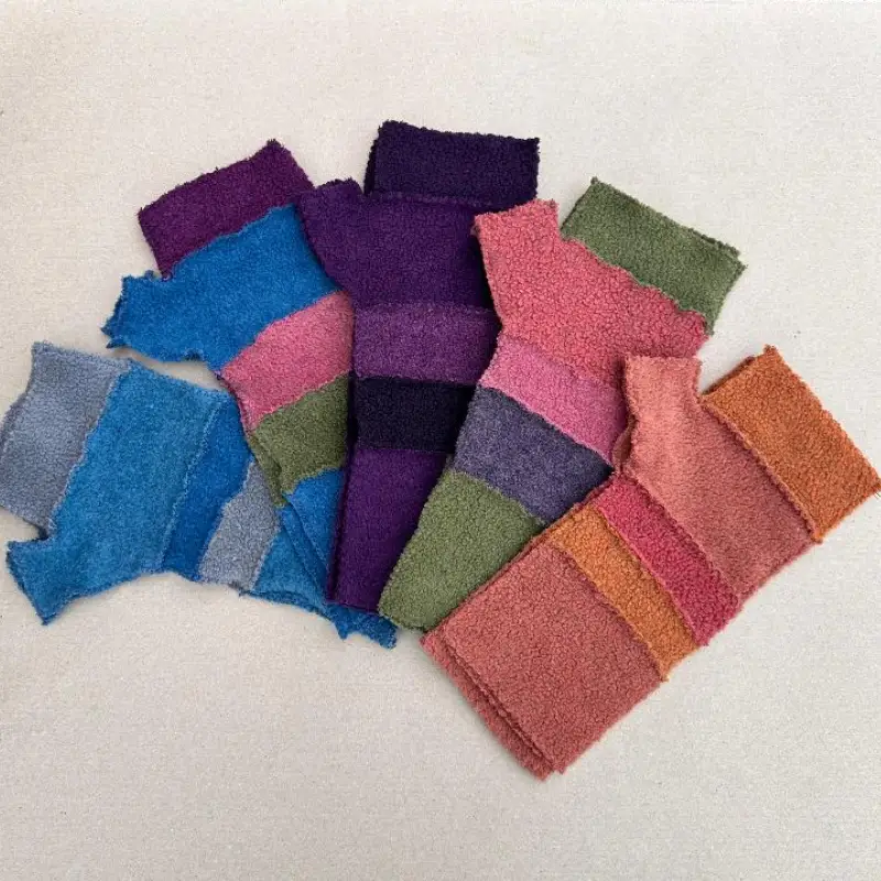 an array of Feeline Clothing stripey mittens in many colours, ranging from pink and orange, to green to blue to purple..
