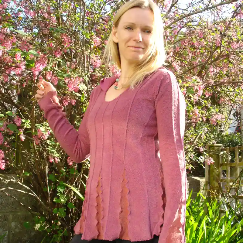 Feeline Clothing top with hood, in sunset colour way, modelled against a background of pink blossom
